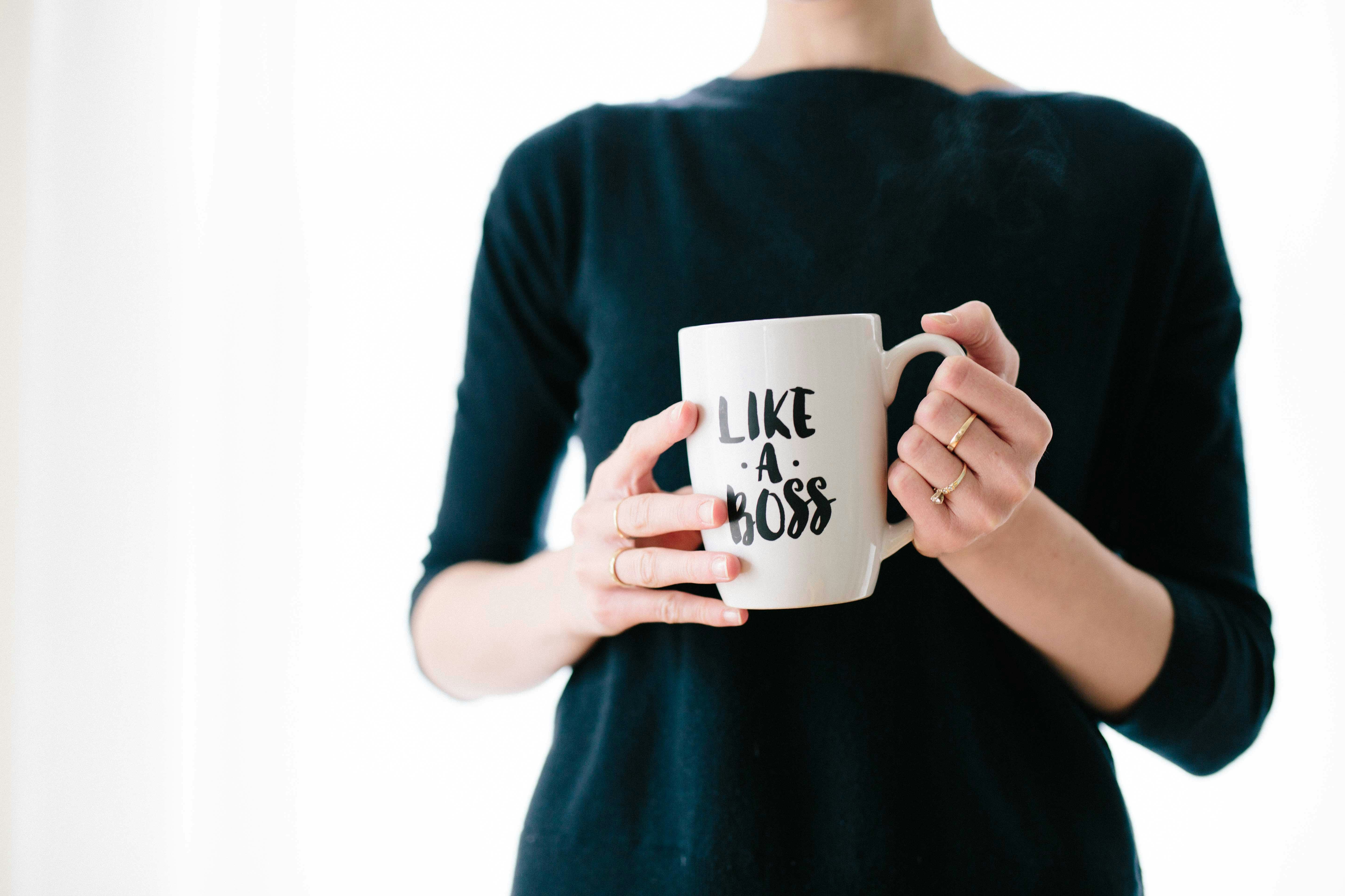 Woman holding "Like A Boss" mug. Photo by Brooke Lark on Unsplash