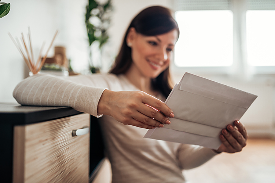 Does direct mail marketing work in real estate - young woman sorting through her mail