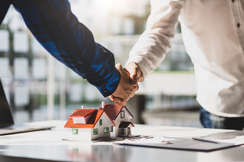 Real estate agents shake hands during a real estate negotiation